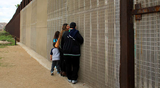 Families separated by the two countries chat along the U.S.-Mexico border fence at Border Field State Park, California, on Nov. 19, 2016.  Photo courtesy of Reuters/Mike Blake